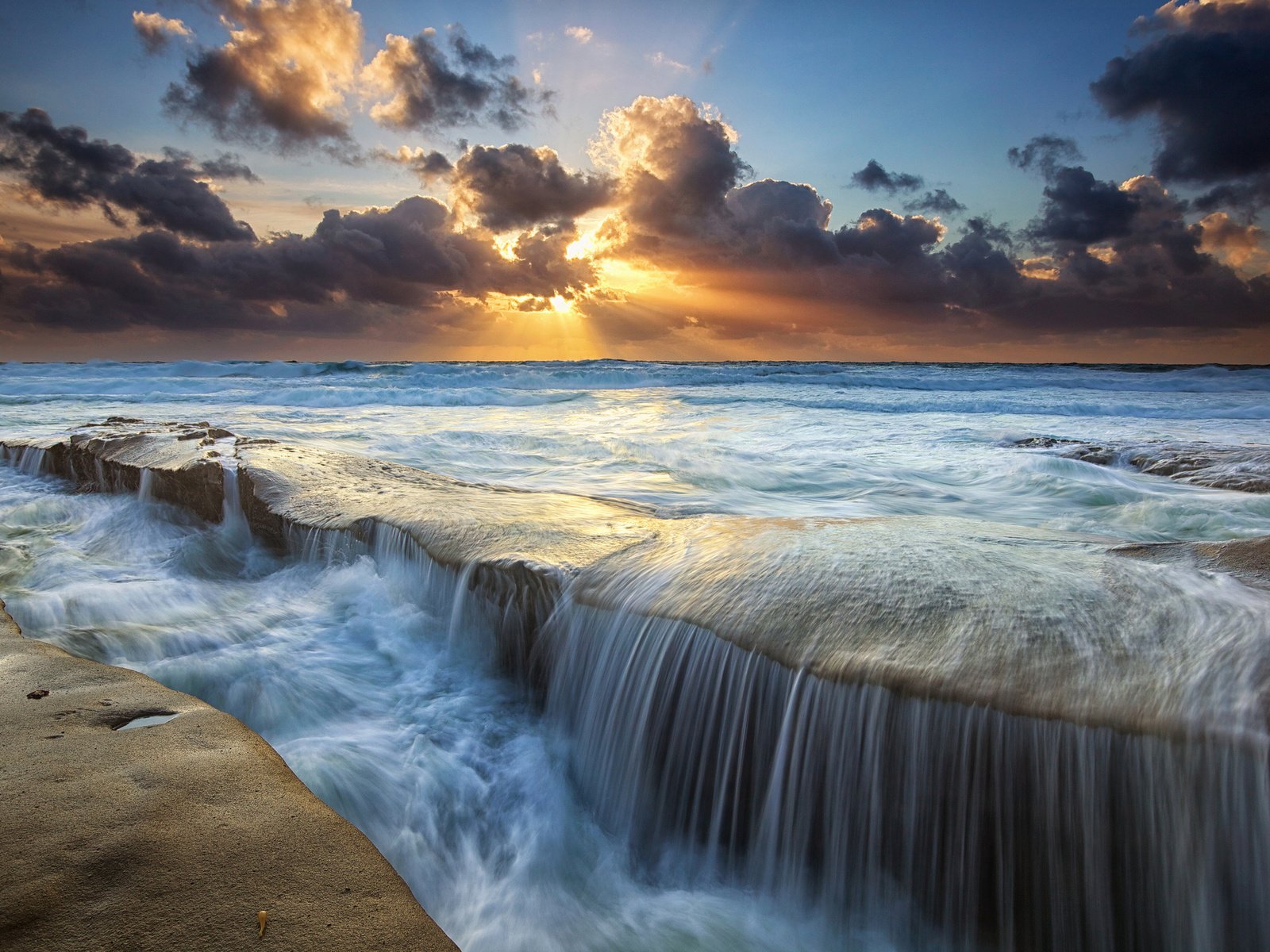 Обои небо, облака, солнце, камни, лучи, море, водопад, поток, the sky, clouds, the sun, stones, rays, sea, waterfall, stream разрешение 2048x1365 Загрузить