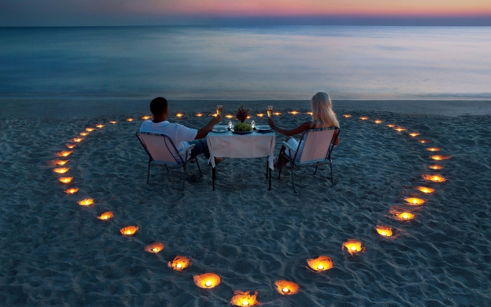 Обои мужчина и женщина пьют вино на берегу, свечи на песке в форме сердца, man and woman drinking wine on the shore, candles on the sand in the shape of a heart разрешение 1920x1080 Загрузить