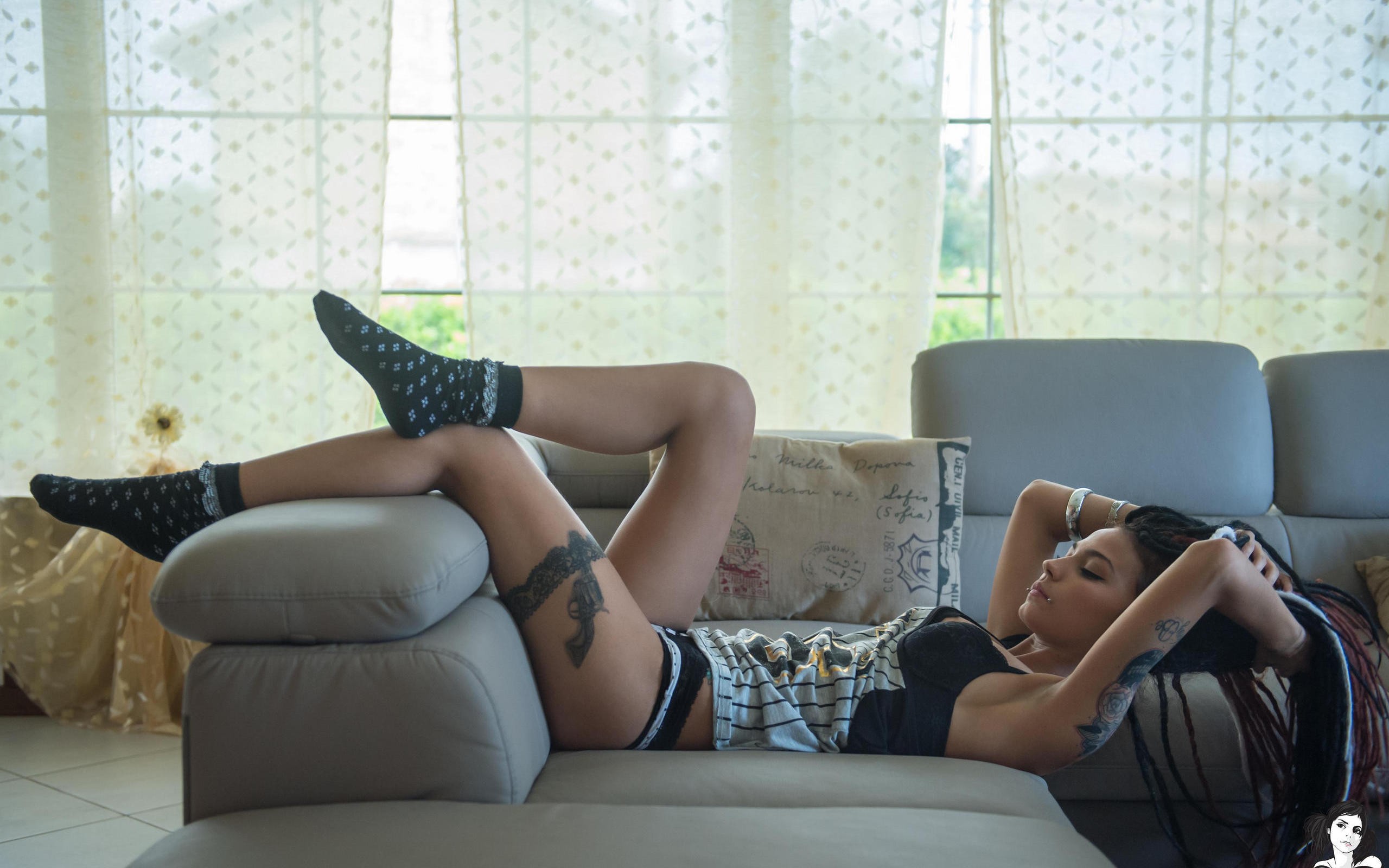 Vanessa Decker показывает татуированные ножки на диване
