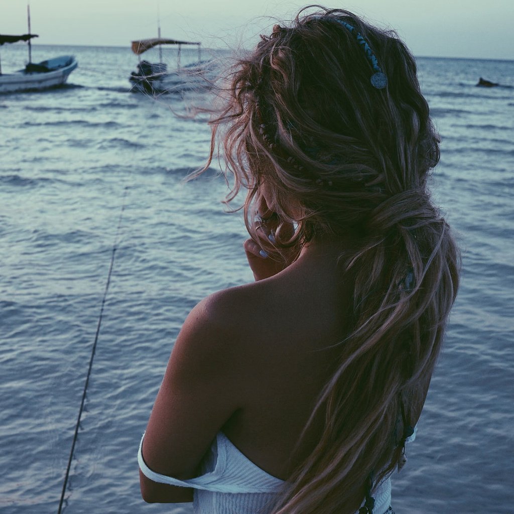 Блондинка на берегу моря со спины