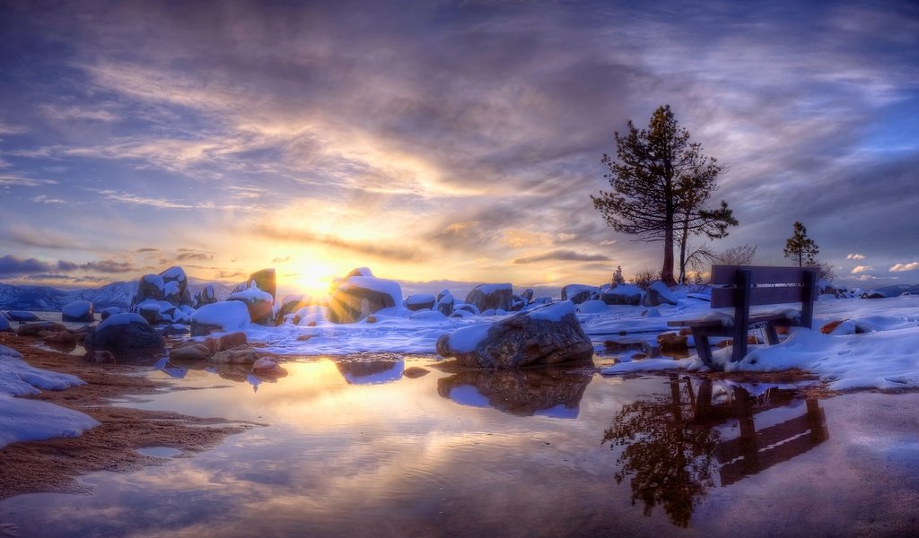 Обои небо, деревья, вода, солнце, снег, камни, зима, скамейка, the sky, trees, water, the sun, snow, stones, winter, bench разрешение 1920x1200 Загрузить