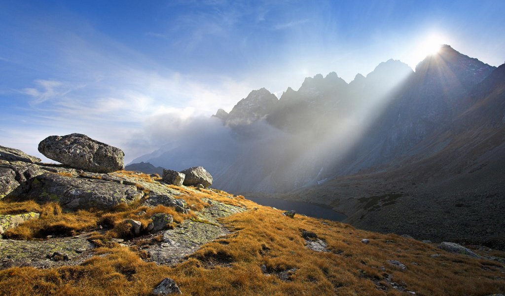 Обои горы, солнце, камни, растения, лучи, mountains, the sun, stones, plants, rays разрешение 1920x1080 Загрузить