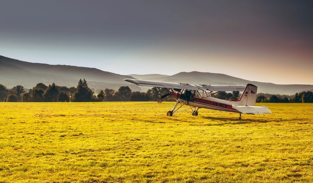 Обои трава, горы, лес, самолет, поле, дымка, солнечно, grass, mountains, forest, the plane, field, haze, sunny разрешение 2200x1461 Загрузить