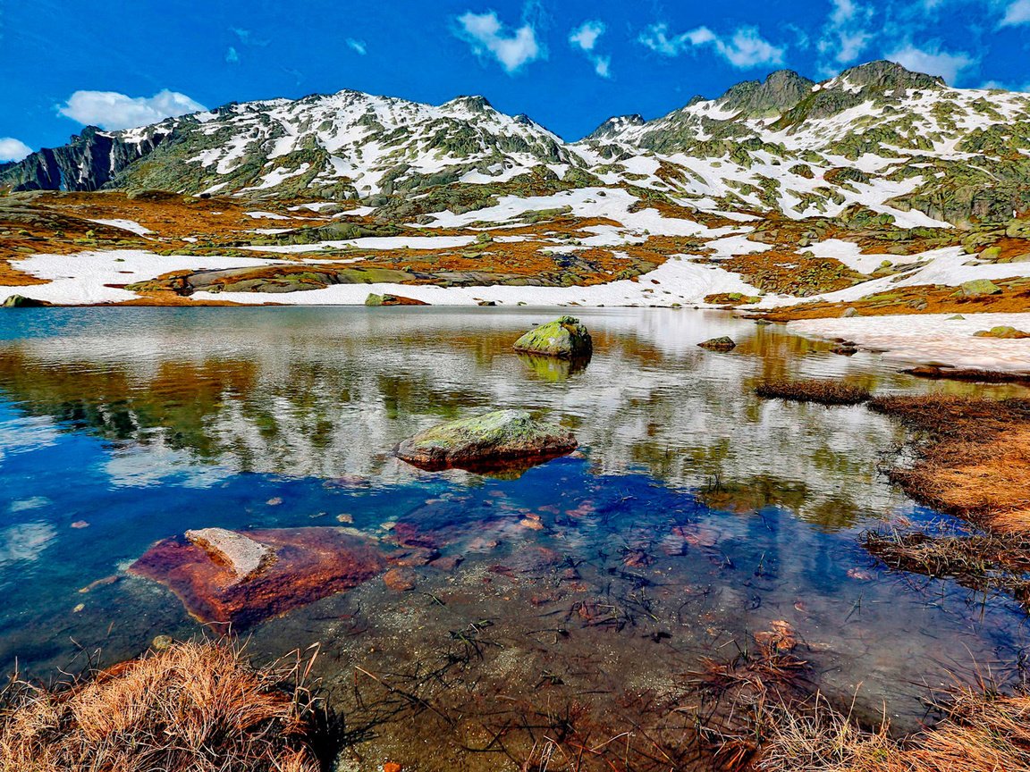 Обои небо, облака, озеро, горы, снег, камни, the sky, clouds, lake, mountains, snow, stones разрешение 1920x1265 Загрузить