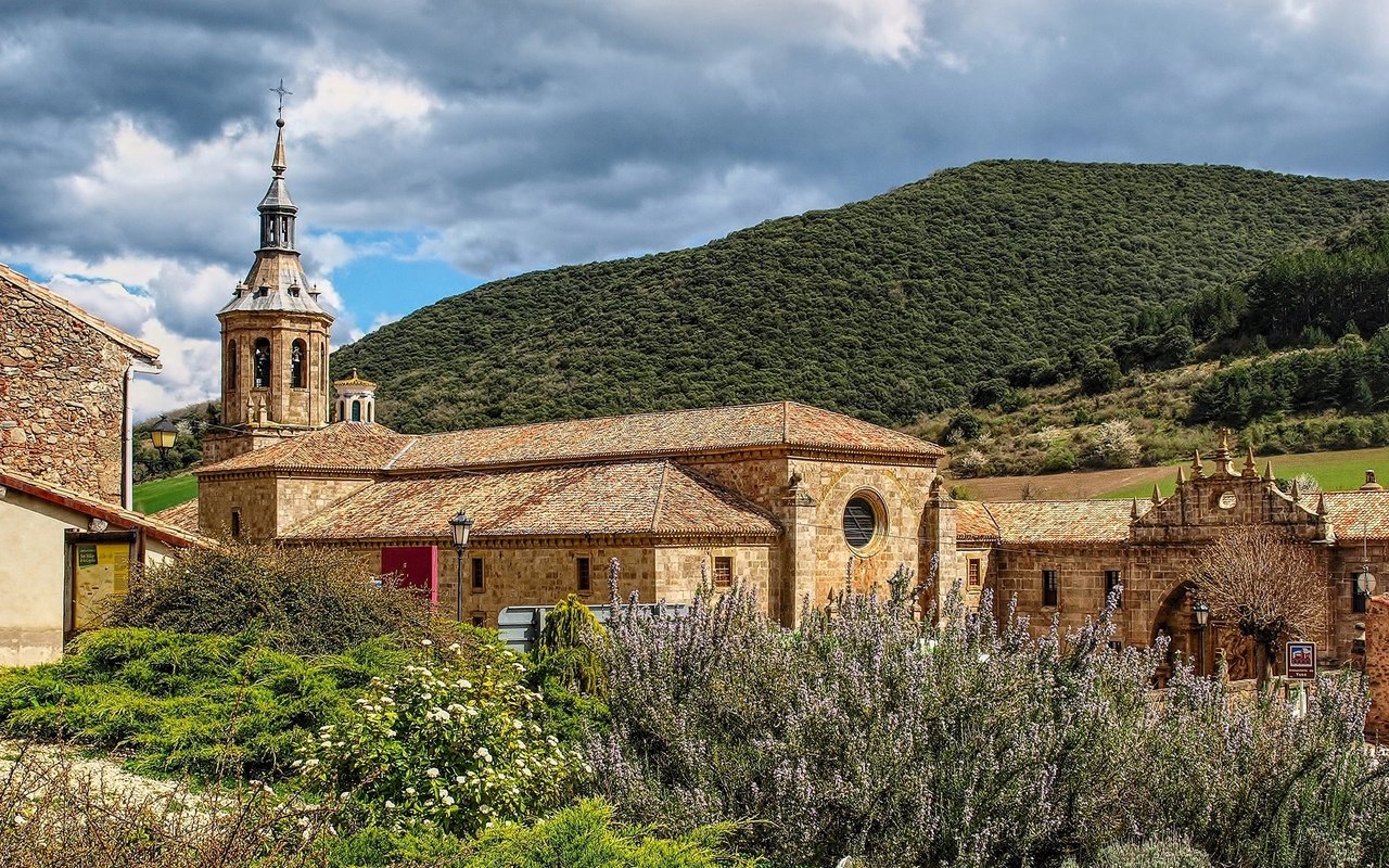 Обои небо, монастырь, трава, la rioja, monasterio de yuso, облака, горы, солнце, лес, кусты, испания, the sky, the monastery, grass, clouds, mountains, the sun, forest, the bushes, spain разрешение 1920x1253 Загрузить