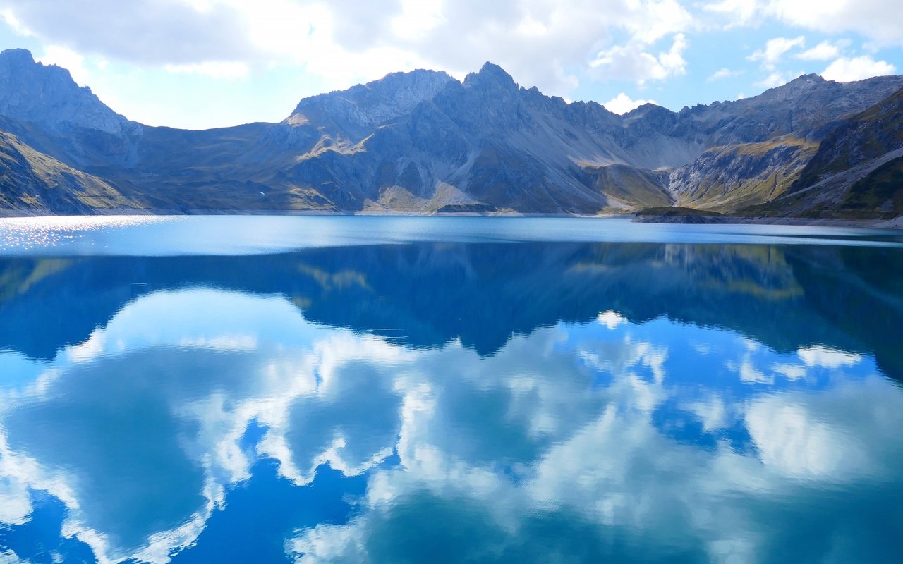 Обои небо, водоем, облака, люнерзе, luner, озеро, lünersee, горы, природа, отражение, пейзаж, австрия, the sky, pond, clouds, lake, mountains, nature, reflection, landscape, austria разрешение 3840x2160 Загрузить