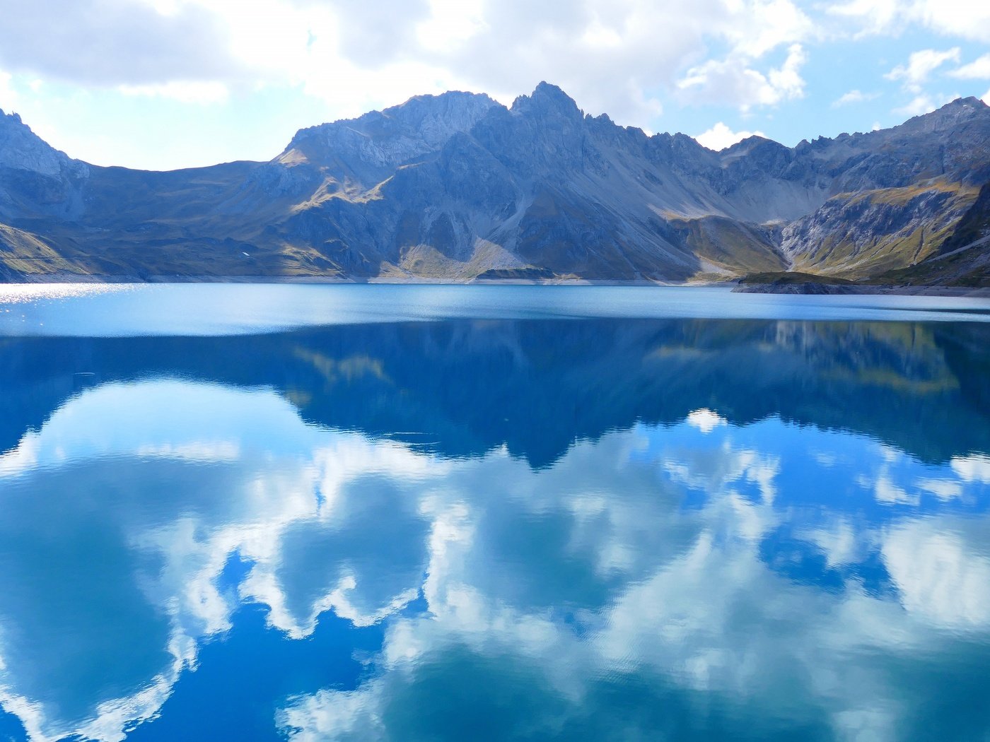 Обои небо, водоем, облака, люнерзе, luner, озеро, lünersee, горы, природа, отражение, пейзаж, австрия, the sky, pond, clouds, lake, mountains, nature, reflection, landscape, austria разрешение 3840x2160 Загрузить