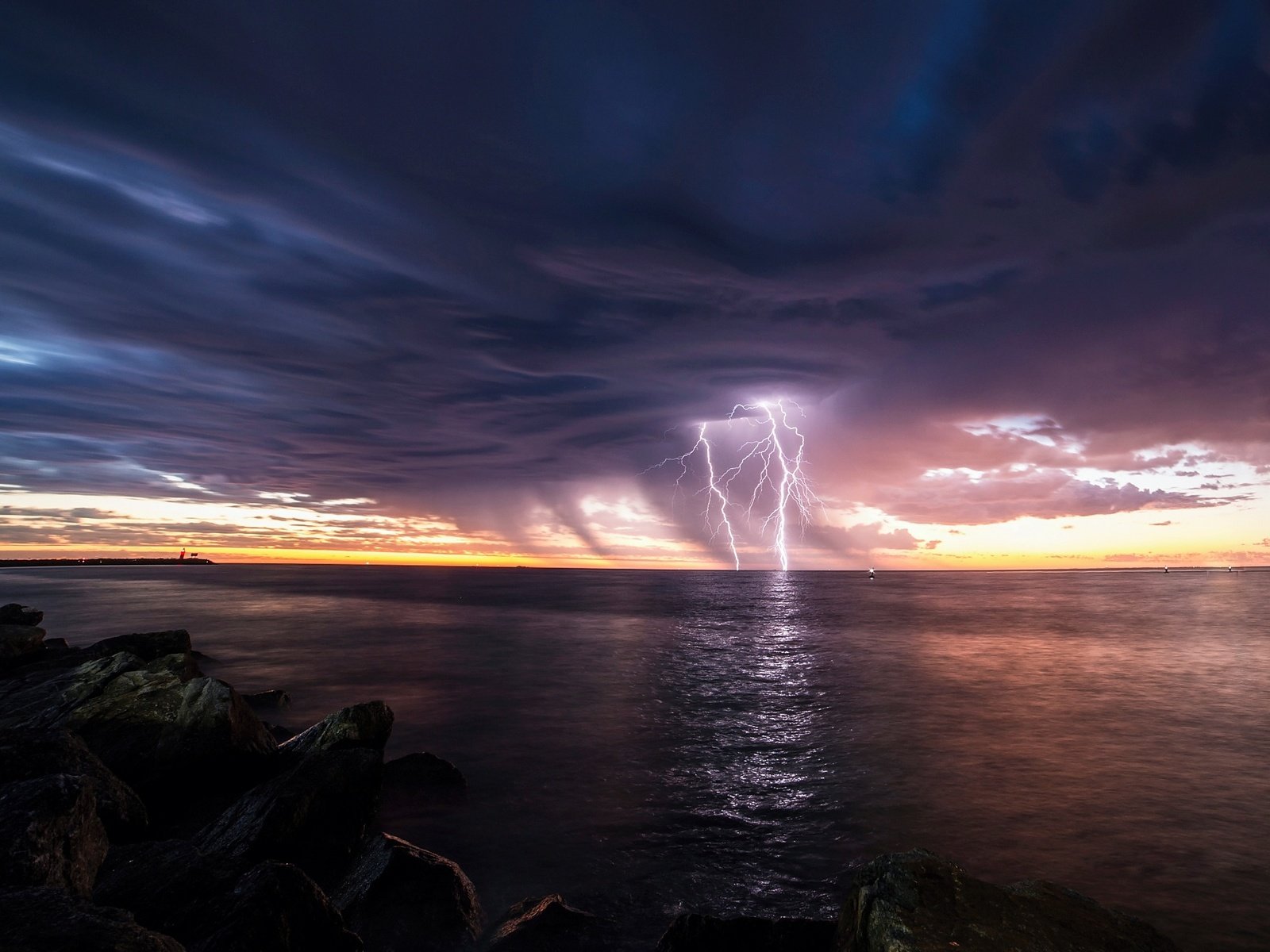 Обои небо, свет, камни, берег, тучи, море, молнии, the sky, light, stones, shore, clouds, sea, zipper разрешение 2048x1366 Загрузить