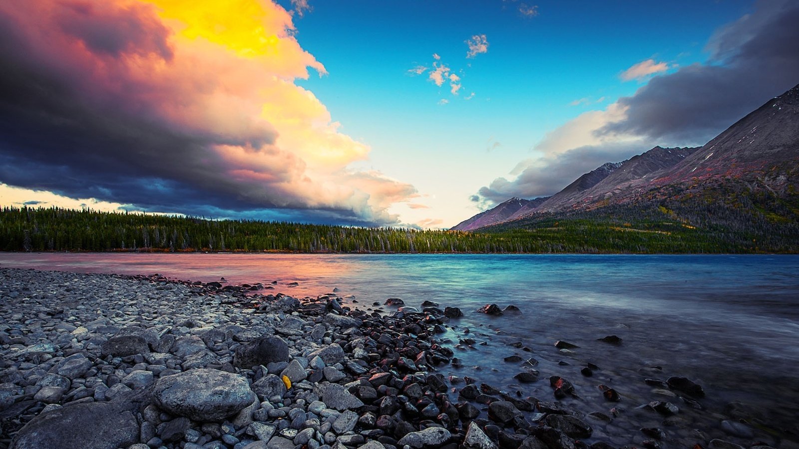 Обои небо, облака, деревья, река, горы, камни, лес, закат, the sky, clouds, trees, river, mountains, stones, forest, sunset разрешение 1920x1200 Загрузить