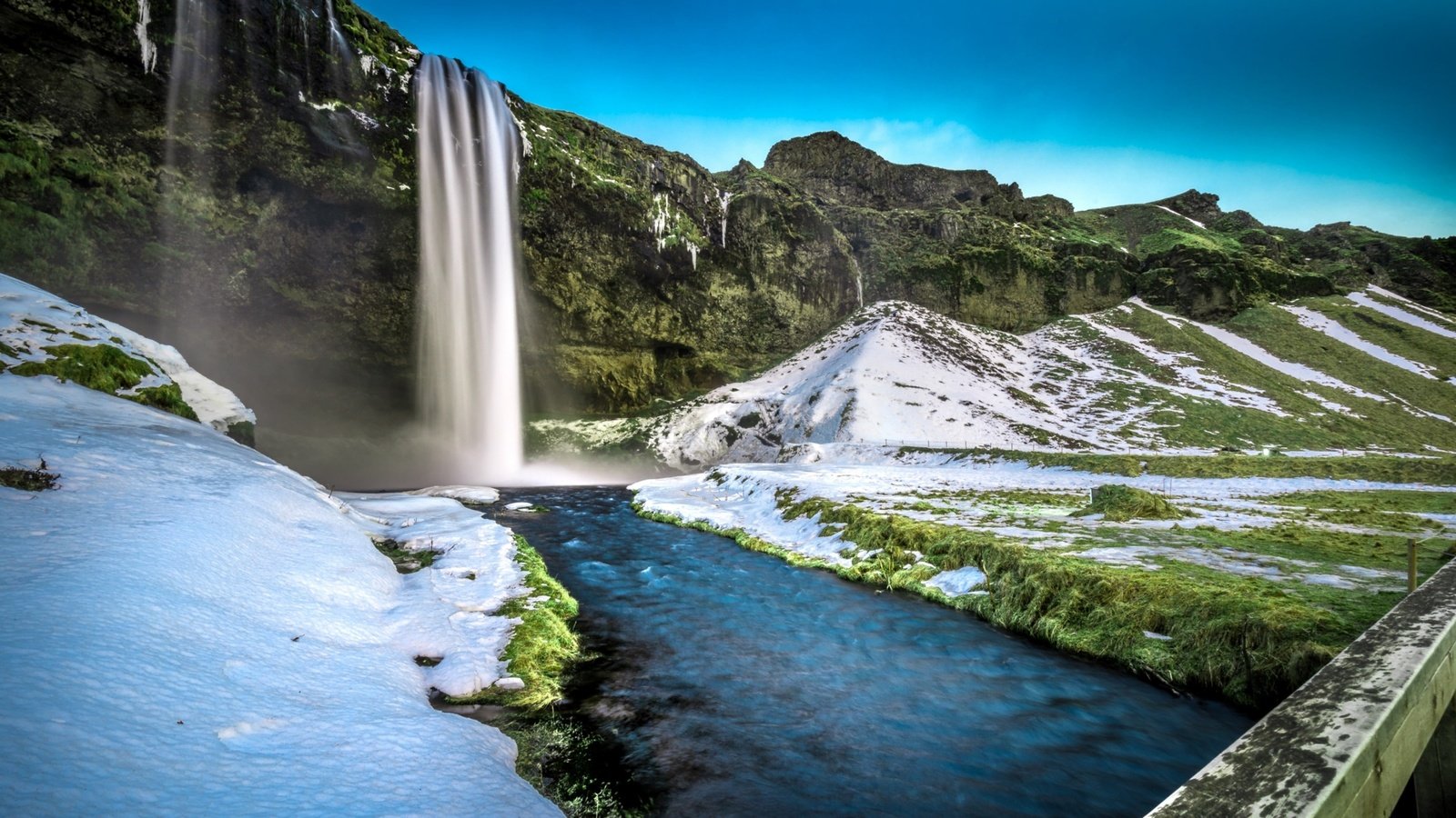 Обои трава, скалы, снег, мост, водопад, исландия, селйяландсфосс, grass, rocks, snow, bridge, waterfall, iceland, seljalandsfoss разрешение 3840x2160 Загрузить