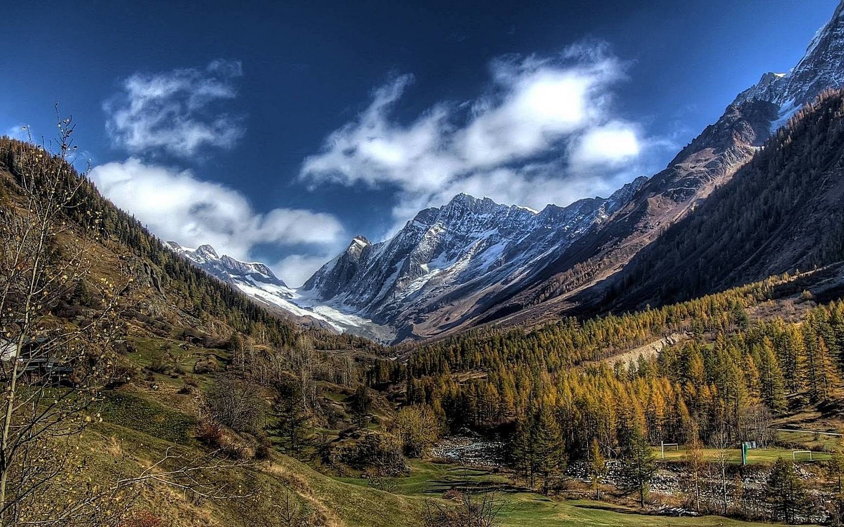 Обои небо, облака, деревья, горы, снег, лес, вершины, долина, the sky, clouds, trees, mountains, snow, forest, tops, valley разрешение 1920x1080 Загрузить