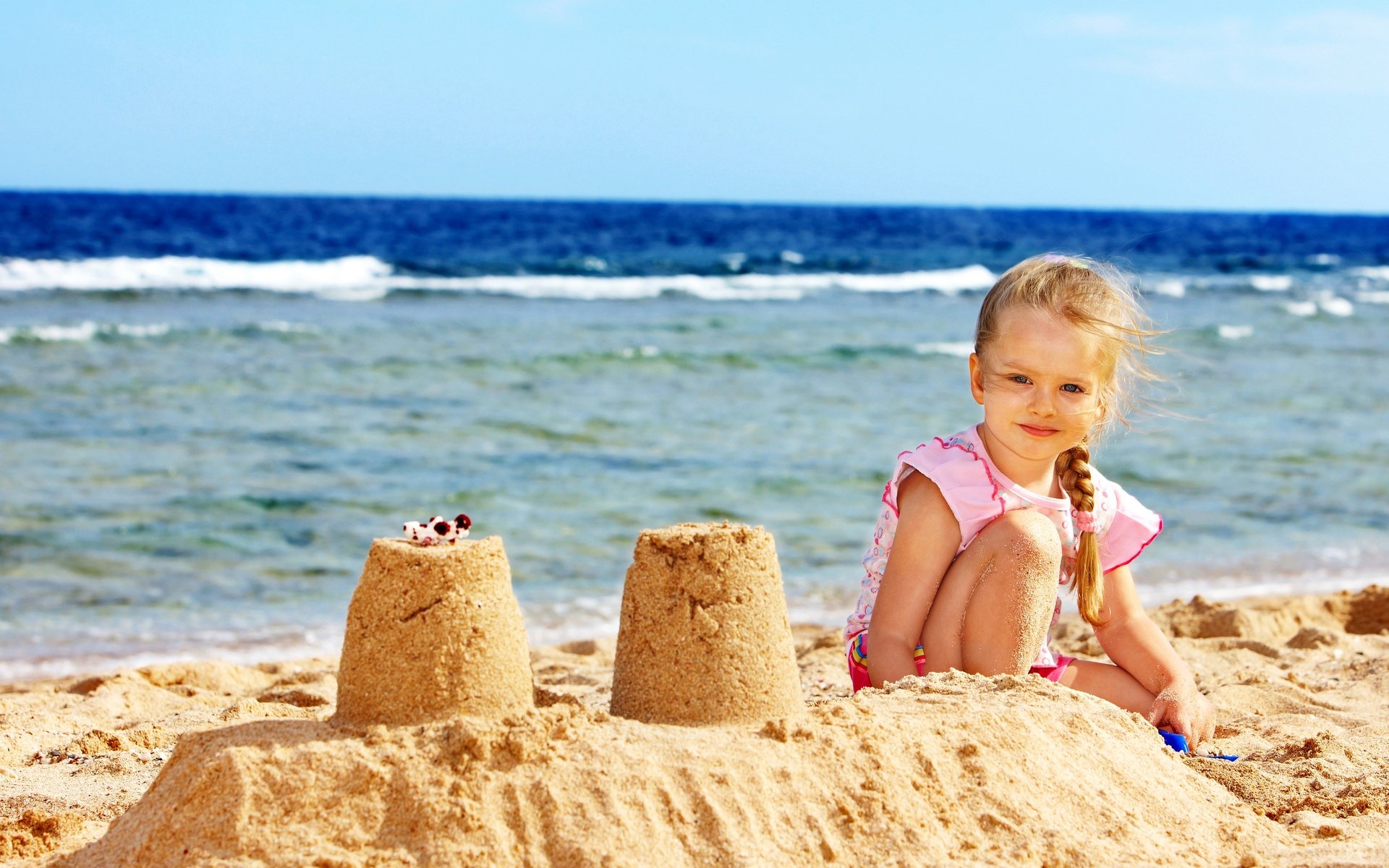 Девочка копается в песке на пляже бесплатно