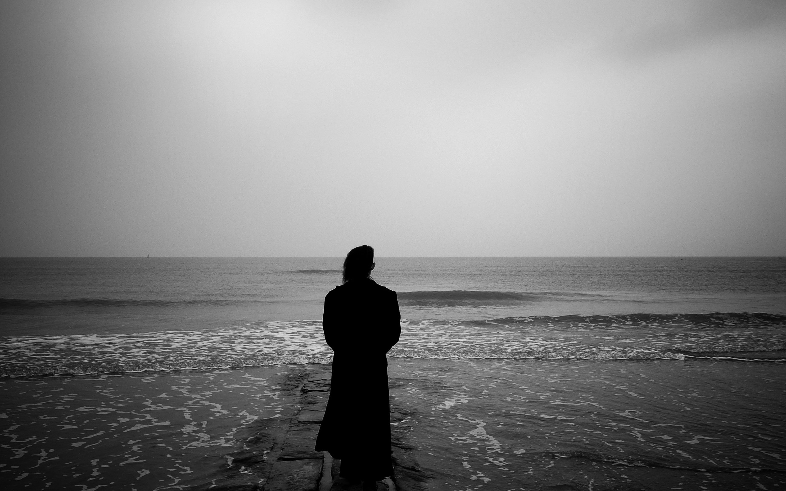 Черное белое фото грустное. Одинокий человек на берегу моря. Море одиночество. Одиночество на берегу моря. Одинокий человек.