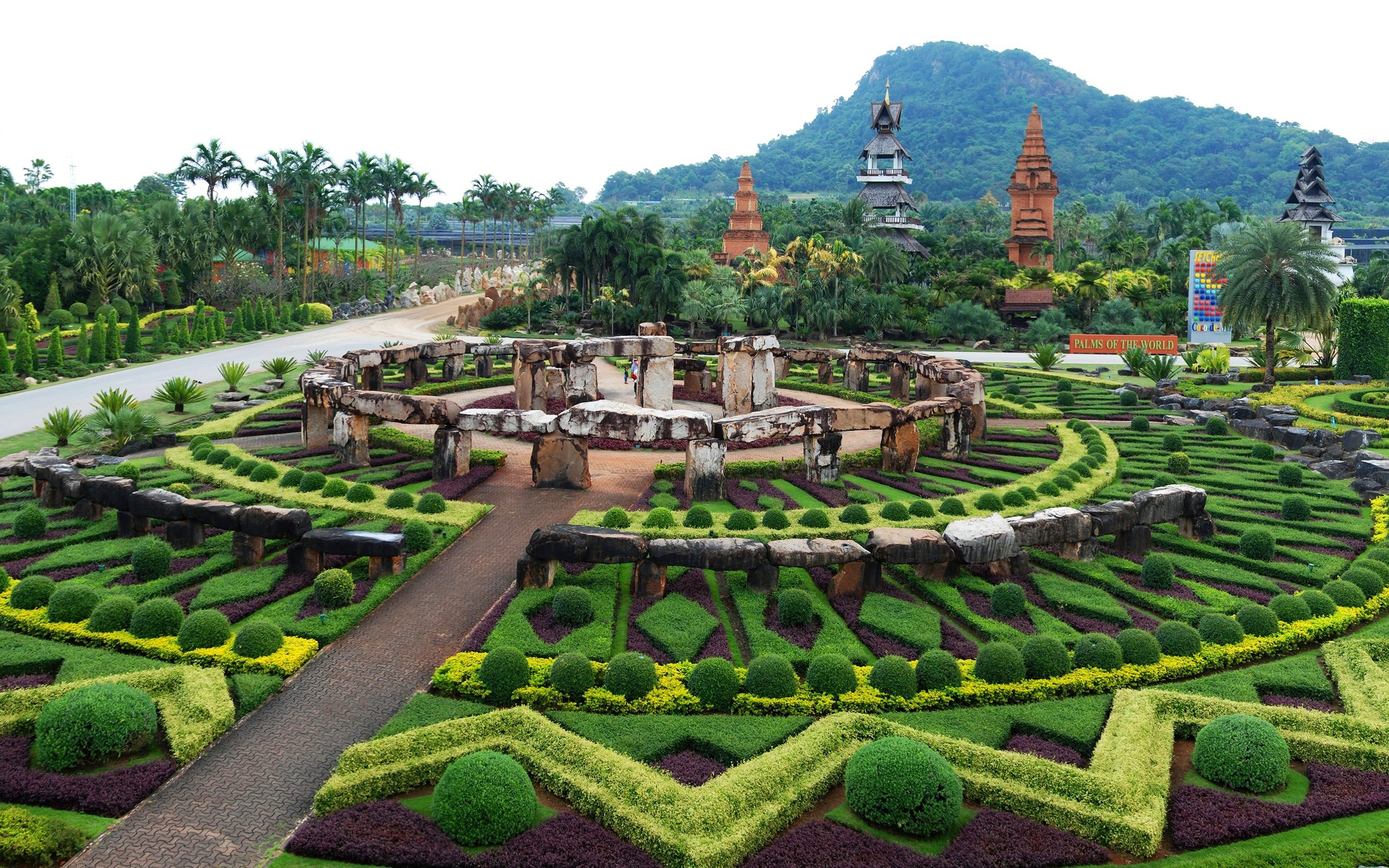 Обои деревья, пальмы, камни, таиланд, лес, джунгли, дизайн, nong nooch tropical botanical garden, парк, кусты, панорама, гора, trees, palm trees, stones, thailand, forest, jungle, design, park, the bushes, panorama, mountain разрешение 3200x1655 Загрузить