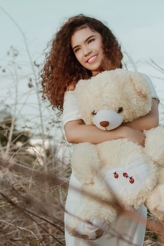 Обои девушка, плюшевый мишка, улыбка, сухая трава, взгляд, рыжая, игрушка, модель, кудри, лицо, girl, teddy bear, smile, dry grass, look, red, toy, model, curls, face разрешение 5000x3333 Загрузить