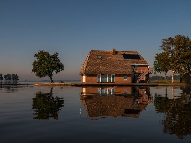 Обои небо, деревья, вода, отражение, водоем, дом, домик, крыша, водная гладь, water surface, the sky, trees, water, reflection, pond, house, roof разрешение 3840x2160 Загрузить