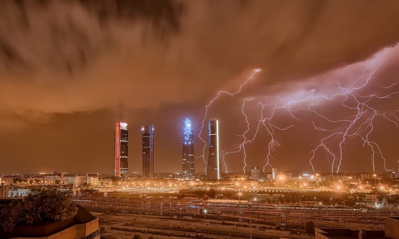 Обои ночь, молния, город, небоскребы, здания, испания, мадрид, night, lightning, the city, skyscrapers, building, spain, madrid разрешение 2560x1440 Загрузить