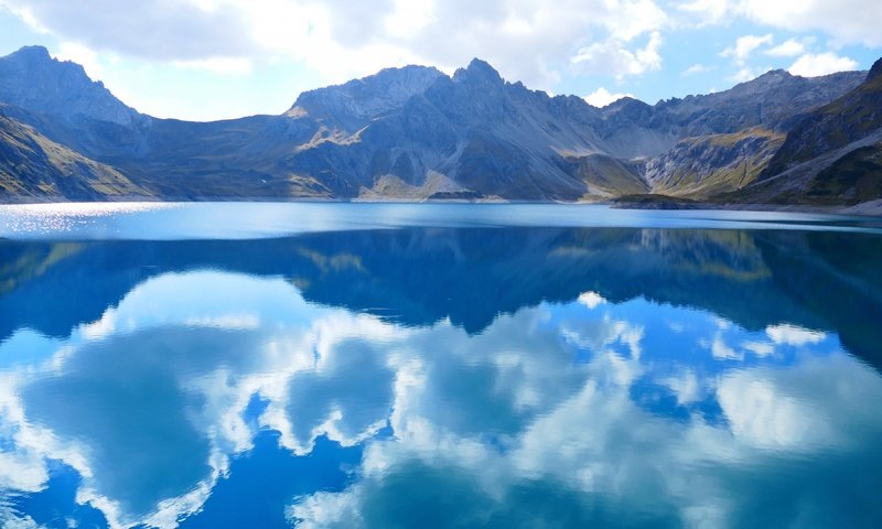 Обои небо, водоем, облака, люнерзе, luner, озеро, lünersee, горы, природа, отражение, пейзаж, австрия, the sky, pond, clouds, lake, mountains, nature, reflection, landscape, austria разрешение 3840x2160 Загрузить