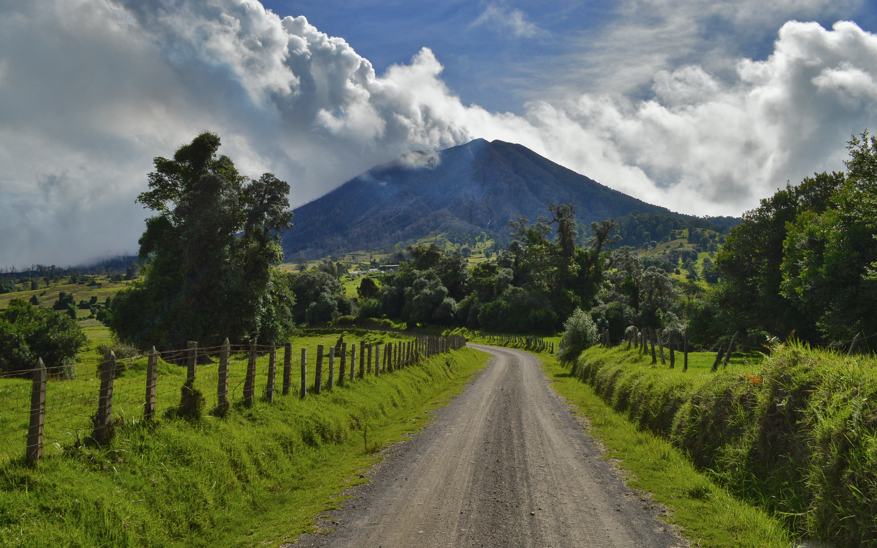 Обои небо, дорога, облака, деревья, природа, забор, вулкан, the sky, road, clouds, trees, nature, the fence, the volcano разрешение 2880x1800 Загрузить