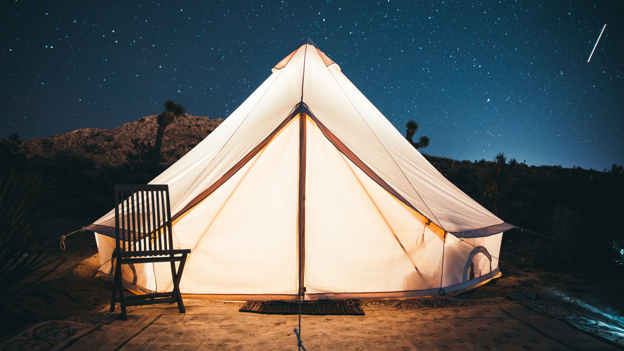 Обои небо, свет, звезды, стул, палатка, вход, kal loftus, the sky, light, stars, chair, tent, entrance разрешение 2112x1188 Загрузить